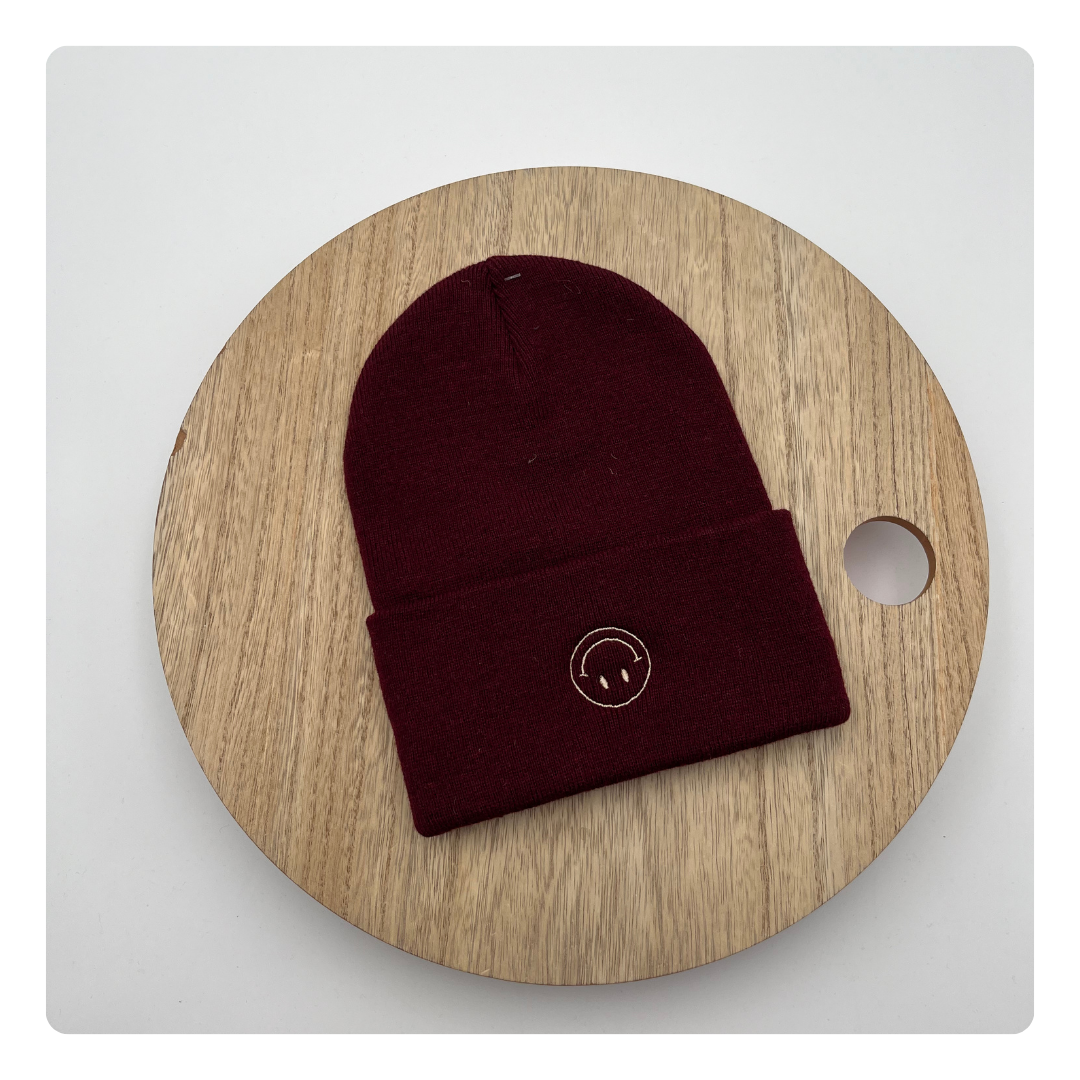 Bordeaux muts met geborduurde omgekeerde smiley – speels en persoonlijk accessoire