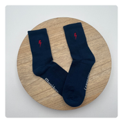 Donkerblauwe sokken met rode bliksemschicht geborduurd – krachtig en opvallend detail
